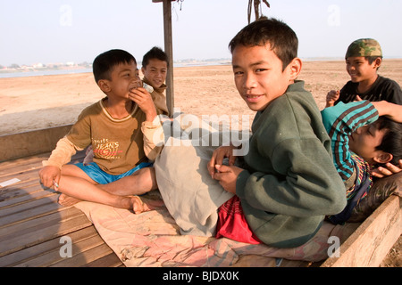 A group of boys relax under a small hut on the shores of the Mekong River in Savannakhet, Lao People's Democratic Republic. Stock Photo