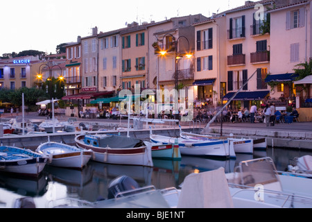 Cassis, Provence, France. View across the harbour to waterside restaurants at dusk. Stock Photo