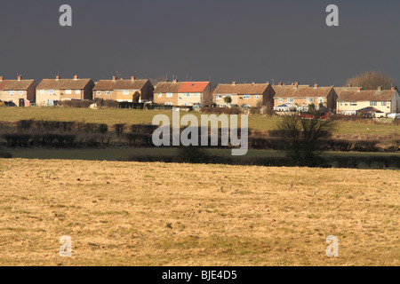 Houses and fields are highlighted by a break in the clouds,prior to stormy weather,across the rooftops of Thurcroft,Rotherham. Stock Photo