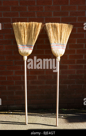 two brooms for sale and on display outside a hardware shop in Gerrards Cross Buckinghamshire UK Stock Photo