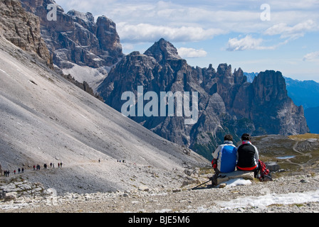 A young couple taking in the view of the majestic Dolomite Mountains in Italy. Stock Photo