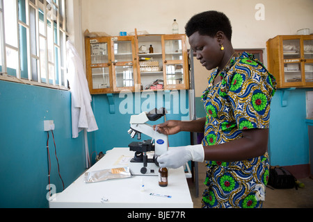 A laboratory technician in Amuria, Uganda examines a patient's blood for signs of malaria. Stock Photo