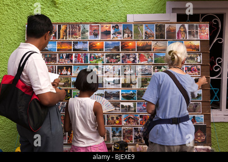 India, Kerala, Kochi, Mattancherry, Jewtown, Indian tourists and western woman browsing display of postcards Stock Photo