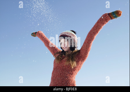 14 year old girl in winter clothing with arms raised Stock Photo