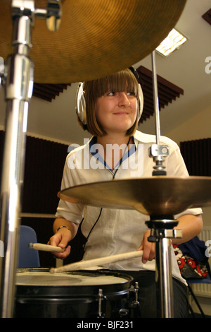 School girl playing drums and cymbals in music lesson. Stock Photo