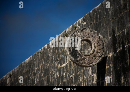 A stone ring juts out from the side of a ball court's of the Mayan ruins of Chichen Itza in Mexico's Yucatan Peninsula Stock Photo