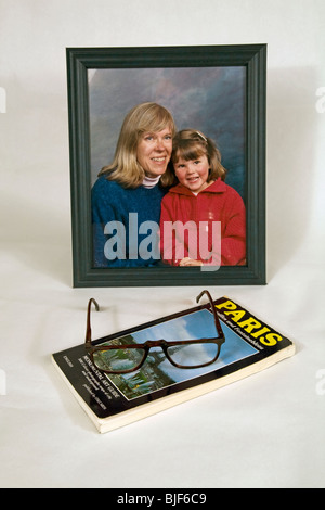 Paris guidebook, reading glasses, and a portrait of a family Stock Photo