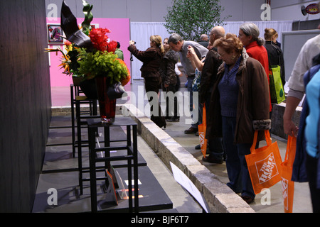 spectators gather around looking at the flower arrangements