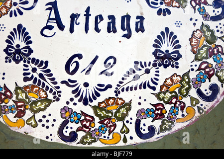 detail of whimsical decorative glazed ceramic house number hand painted with marvelous colored floral design Oaxaca City Mexico Stock Photo