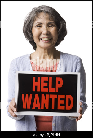 senior woman holding help wanted sign Stock Photo