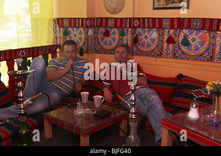 Two men smoking a water pipe, Berlin, Germany Stock Photo