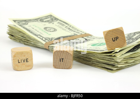 Live it up wood dice with cash on a white background Stock Photo