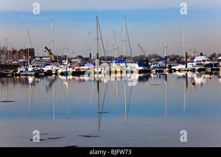 View of Southsea marina with yachts and their masts reflected in the calm water, Eastney, Hampshire, UK Stock Photo