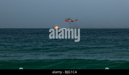 An RNLI lifeboat and an Air Sea Rescue helicopter in a joint exercise off Sennen in Cornwall. Stock Photo