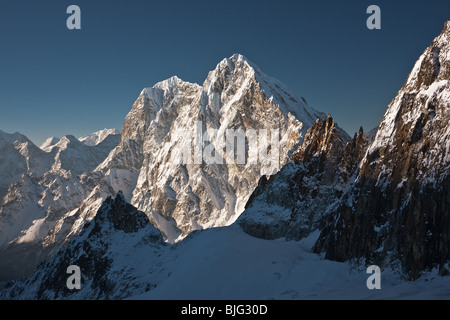 High and steep mountain slope lit by morning sun, Himalayas, Nepal Stock Photo