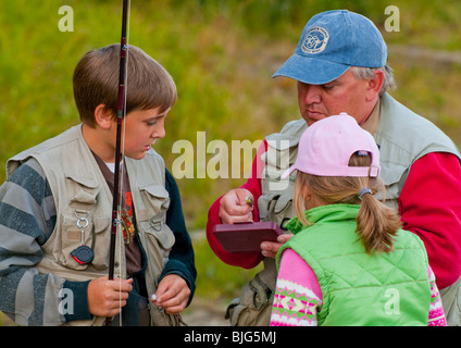 NEW BRUNSWICK, Miramichi River Fly Fishing guide showing young fisherman Atlantic Salmon fly. Stock Photo