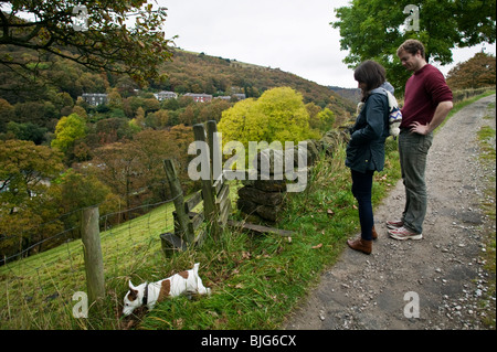 A young couple walk their dog on the hillsides above Hebden Bridge, Yorkshire, England. Stock Photo