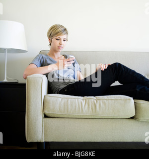 woman on the couch using cell phone Stock Photo