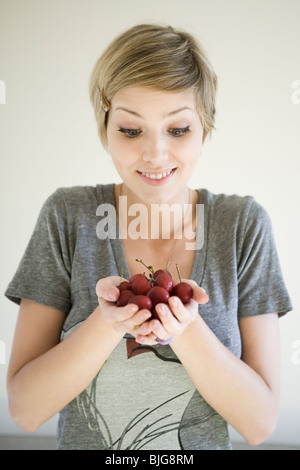 woman with a handful of cherries Stock Photo
