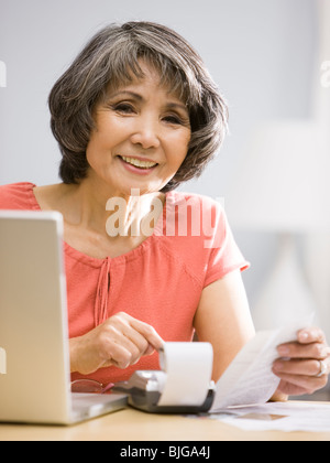 senior woman adding things up Stock Photo