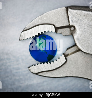 vice grip pliers crushing the earth Stock Photo