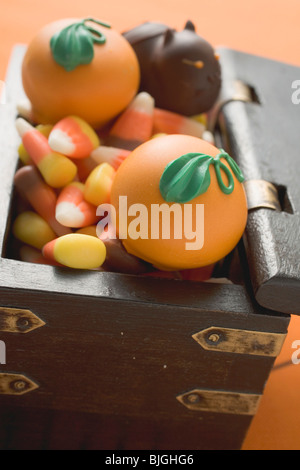 Assorted sweets for Halloween in treasure chest - Stock Photo