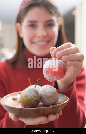 Young woman holding sugared fruit - Stock Photo