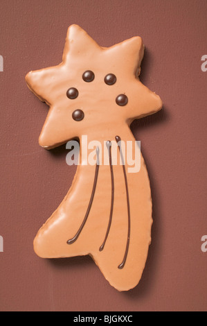 Shooting star biscuit with chocolate icing on brown background - Stock Photo