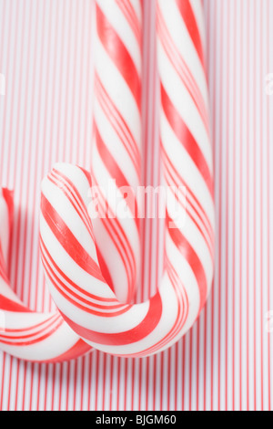 Two candy canes on striped background - Stock Photo