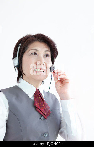 Businesswoman using hands free headset Stock Photo