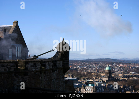 Firing the One O'clock Gun at Edinburgh Castle with pieces of wadding from the blank shell hanging in the air. Stock Photo