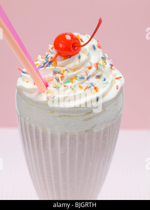 Milkshake with cream, sprinkles and cocktail cherry - Stock Photo