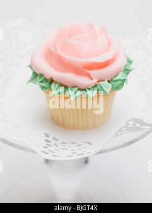Rose muffin on glass cake stand - Stock Photo