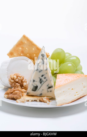 Cheese plate with crackers, nuts and grapes - Stock Photo