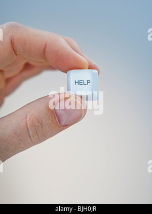 Hand holding keyboard help key Stock Photo