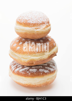 Three doughnuts dusted with icing sugar, stacked - Stock Photo
