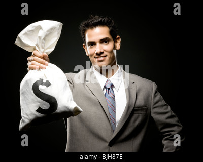 Black Businessman holding black bag full of Ghanaian cedi notes ...
