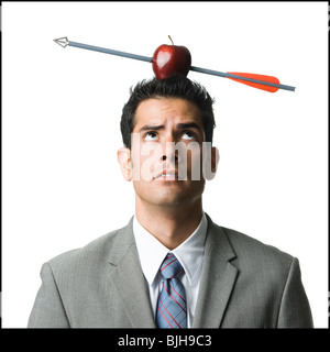 businessman with an apple on his head that has been shot with an arrow Stock Photo