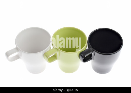 Three white green and black coffee cups in a row isolated on white Stock Photo
