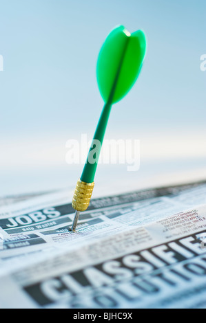 Dart in classifieds Stock Photo