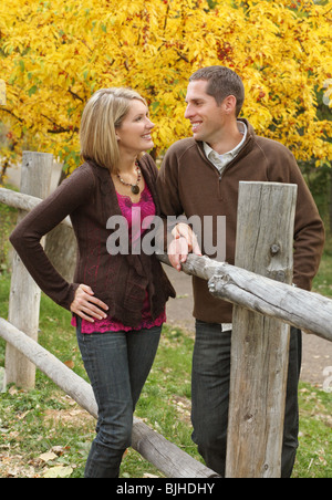 Caucasian couple standing together outdoors and looking at each other Stock Photo