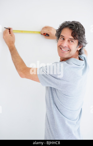 Carpenter marking straight line on wall Stock Photo