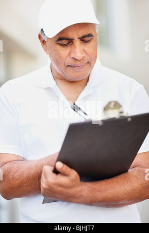 Tradesman writing on clipboard Stock Photo