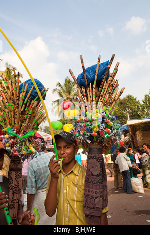 India, Kerala, Kanjiramattom Kodikuthu Moslem festival, man selling flutes and cheap souvenirs outside mosque Stock Photo