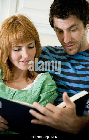 young couple reading a book together Stock Photo