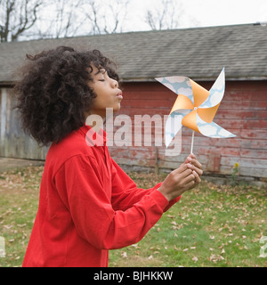 Girl blowing toy windmill Stock Photo