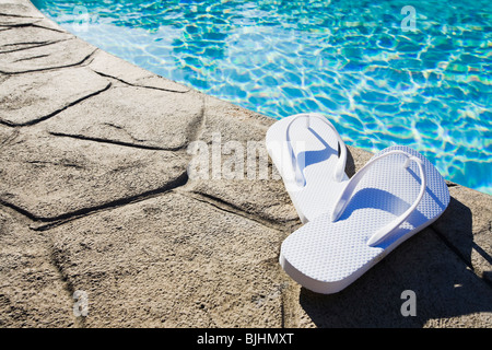 Flip flops by the pool Stock Photo