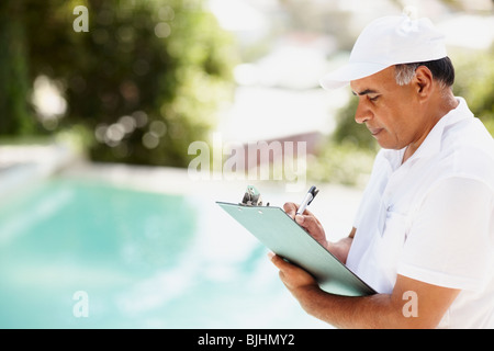 Tradesman writing on clipboard Stock Photo