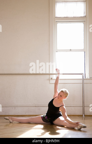 ballerina stretching on the floor of a dance studio Stock Photo