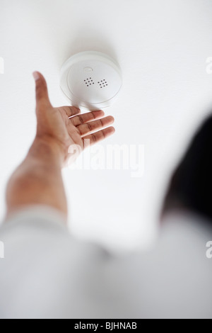 Testing battery in smoke detector Stock Photo